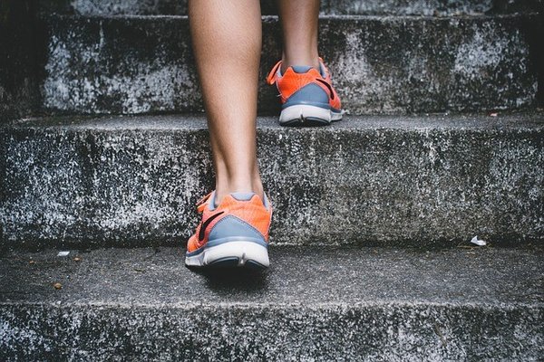 Vrouw loopt trap op op fleurige sneakers.jpg